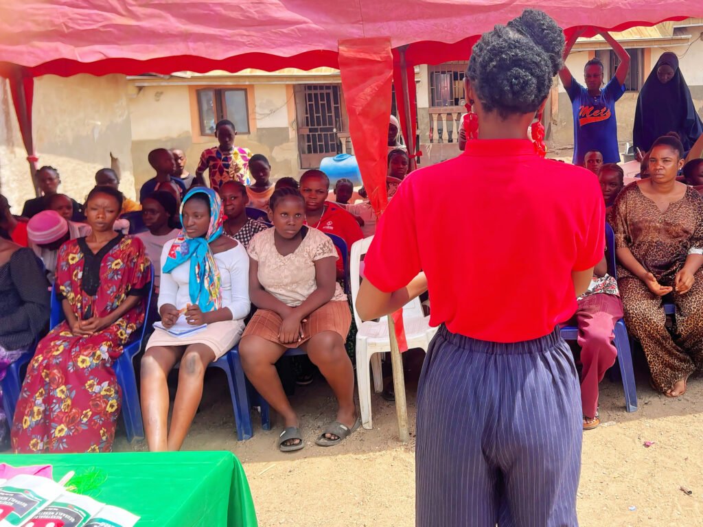 Tracy Yekaghe addressing the girls in a community during one of their menstrual outreaches tagged Pad Her Sustainably.