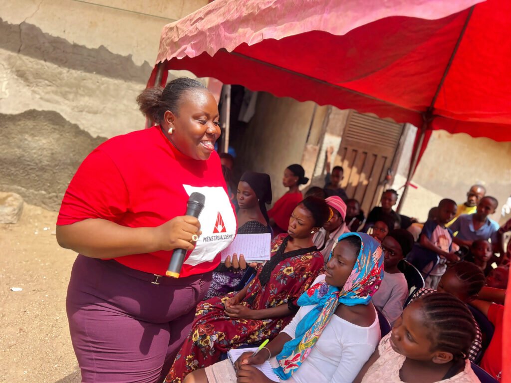 A team member of Menstrualdemy speaking with the girls in a community during a menstrual education session.