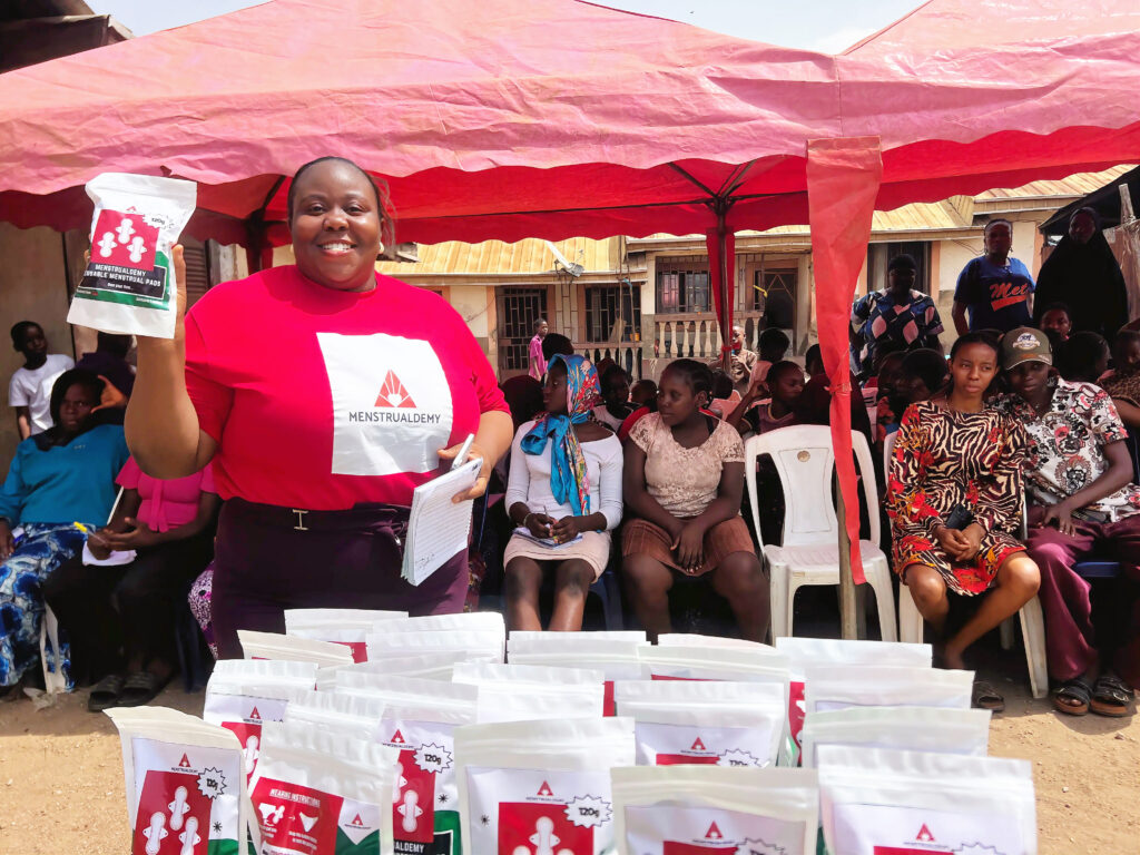 A team member holding up a pack our our Menstrualdemy Reusable Menstrual Pads during one of our outreaches.